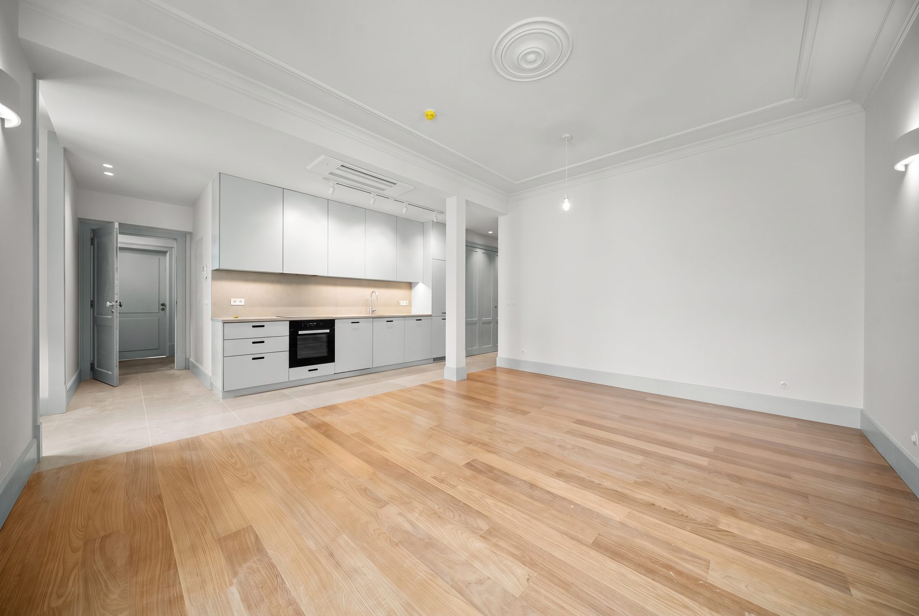 Casa da Coroa T1 — kitchen in soft grey and the hall door