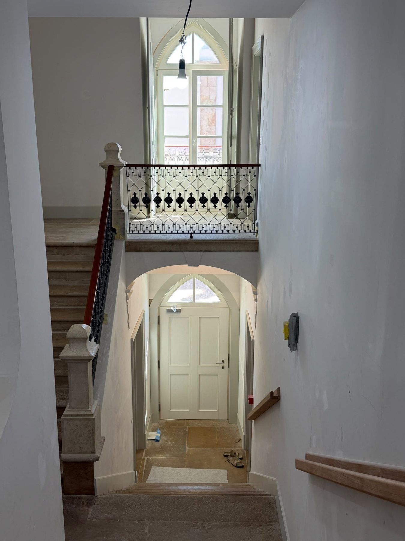 Casa da Coroa — restored stairwell with stone treads and an iron balustrade