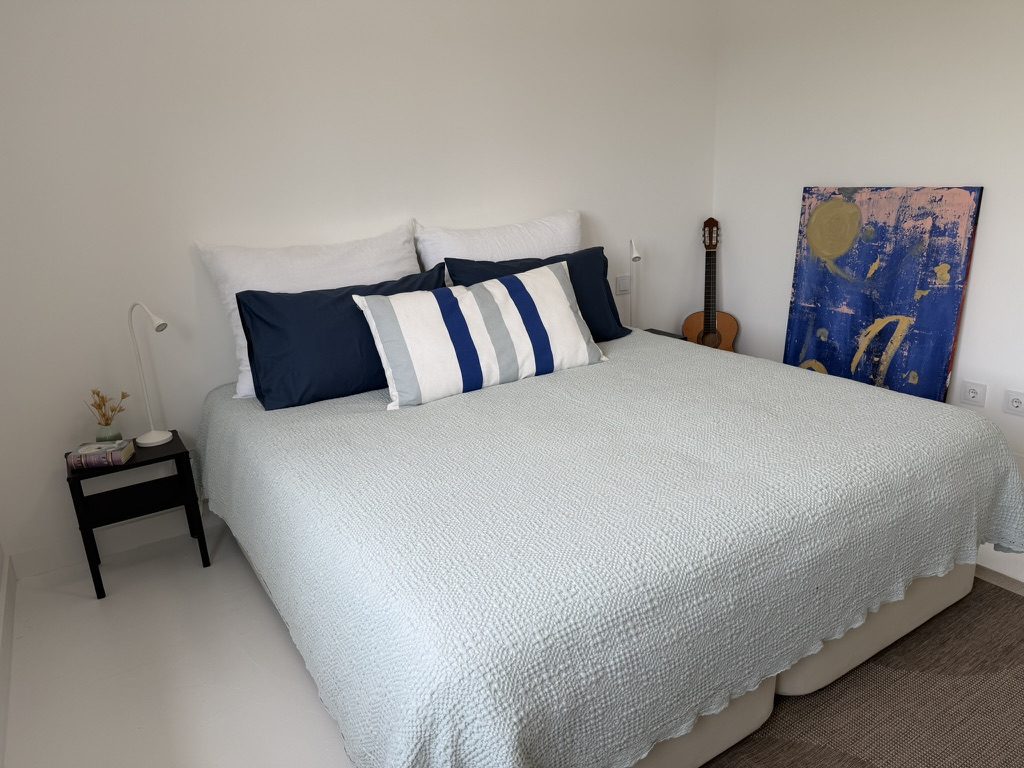 Vale da Rosa, Estoi — double bedroom with navy and striped bedding and abstract artwork