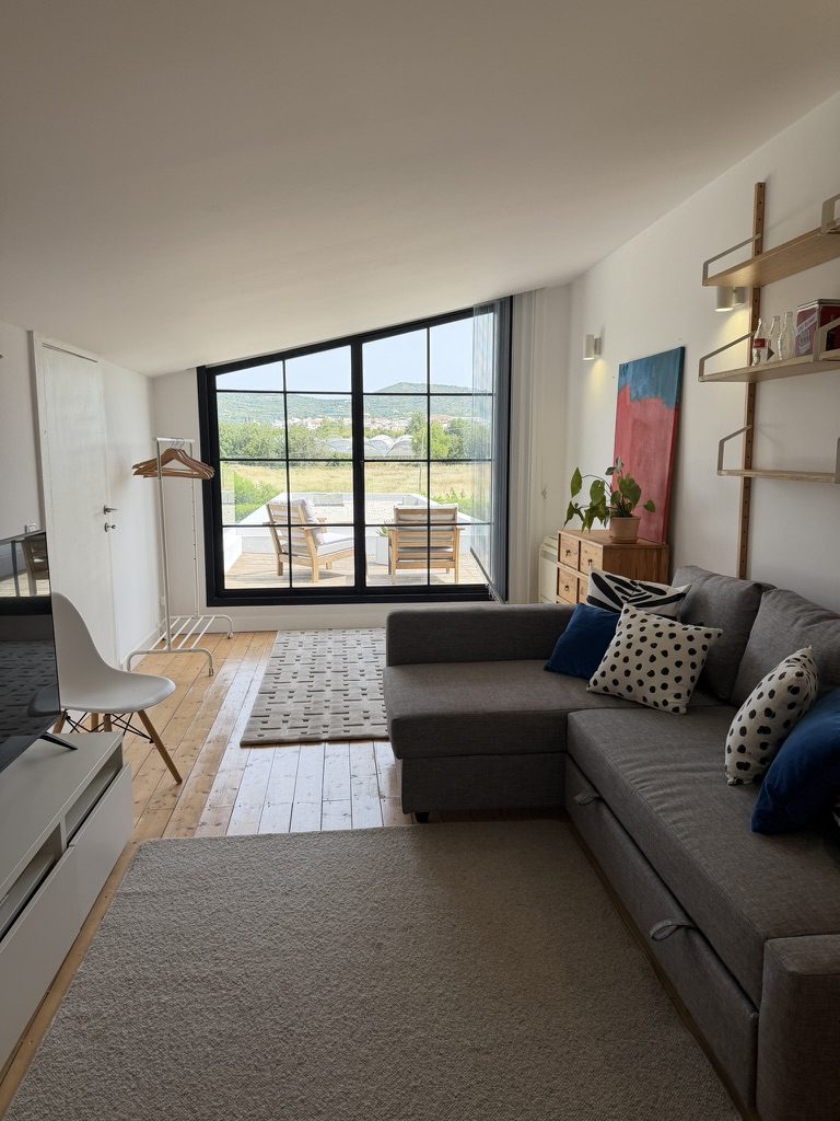Vale da Rosa, Estoi — living room with grey sectional sofa and sliding doors out to the garden