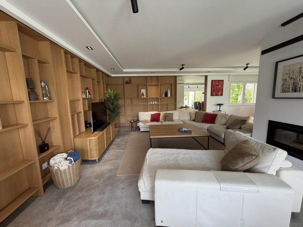 Vale da Rosa, Estoi — main living room with cream sectional sofas, oak-panelled shelving and a modern fireplace