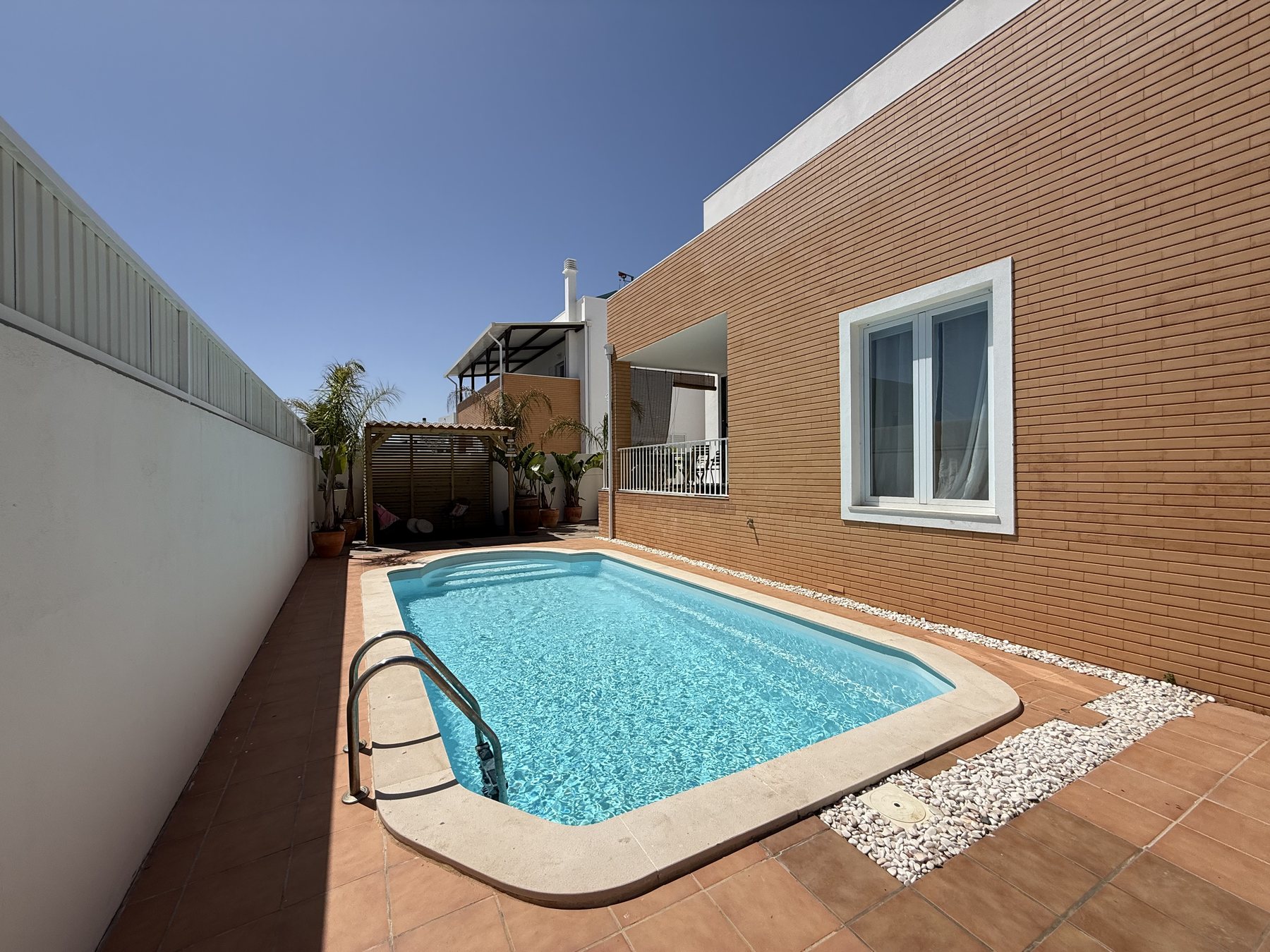 Fuseta villa — heated pool under a pergola beside the house