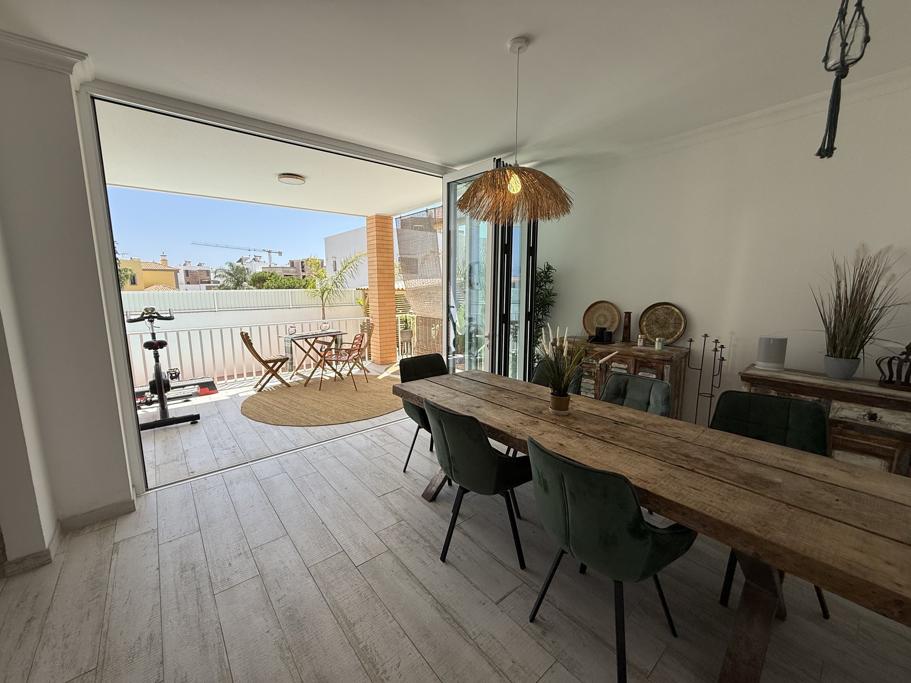 Fuseta villa — dining area opening through glass doors to the pool terrace